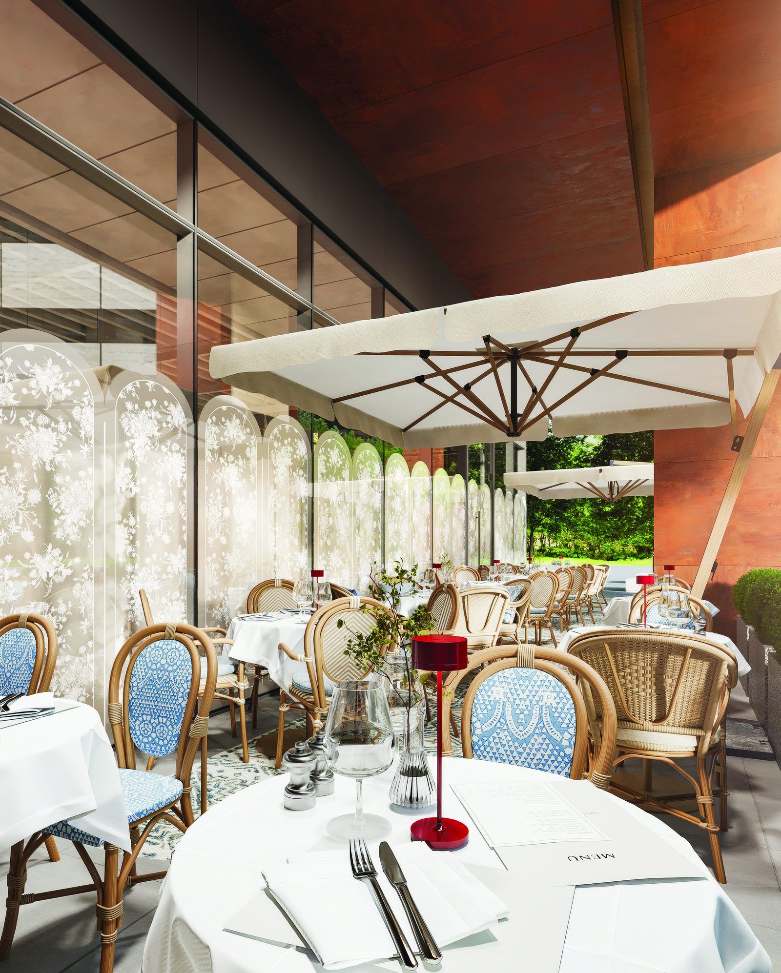 The terrace: lace screens, rattan chairs with blue seats, a red table lamp on white linen
